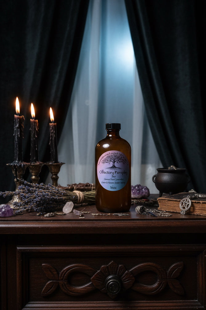 An amber glass bottle of Olfactory Foreplay FEM room spray by Tempestuous Roots Art & Farms LLC on a dark wood nightstand
