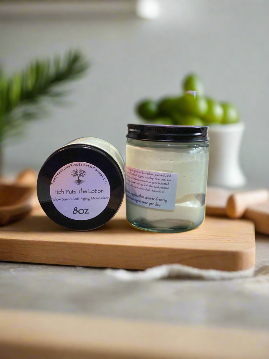 Two jars of Itch Puts the Lotion tallow based, anti-aging moisturizer on a cutting board with a blurred background