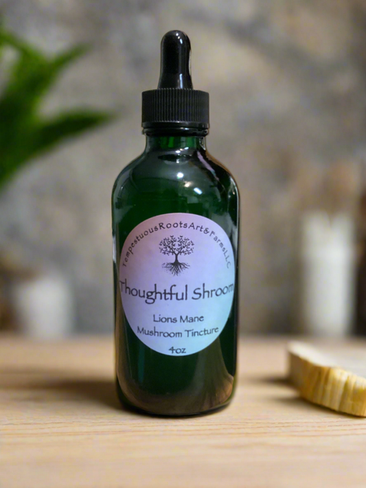 4 oz vottle of 'Thoughtful Shroom' Lions Mane mushroom tincture on a wooden surface with a blurred background