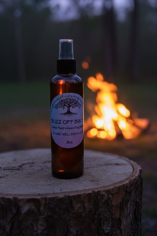 Buzz Off B!$CH!! botanical outdoor spray by Tempestuous Roots on wooden stump with a campfire in a blurred background