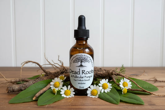 Dead Roots post hair removal oil by Tempestuous Roots Art & Farms LLC on a wooden table surrounded by herbs