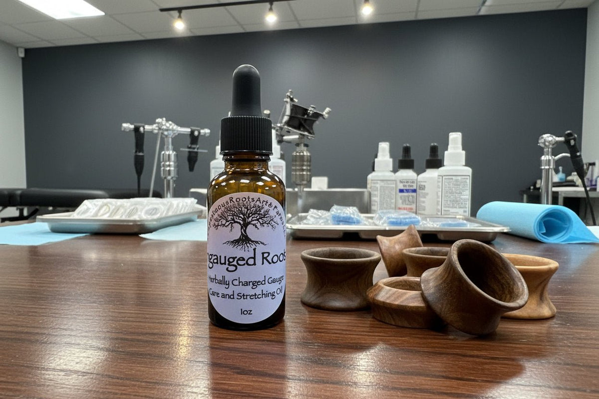 Ingauged Roots Botanical Gauge & Stretching Oil by Tempestuous Roots Art & Farms LLC on a wooden surface next to ear piercing tools and equipment