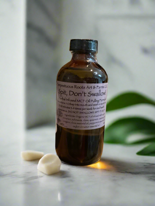 A bottle of organic oil pulling mouthwash with a label that reads 'Spit, Don't Swallow!!' alongside ingredients such as MCT oil, clove, cinnamon, and peppermint. The bottle is on a marble surface with a leafy background.